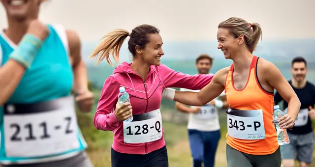 Happy Athletic Women Supporting Each Other While Running Marathon Nature